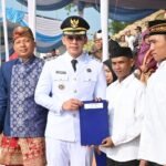 *Merah Putih Menyala dari Beranda Sumatra, Menara Siger Jadi Panggung HUT ke-81 Kemerdekaan RI di Lampung Selatan* *DISKOMINFO LAMSEL, Bakauheni* – Merah putih bukan sekadar warna yang menghiasi perayaan. Dari kawasan Menara Siger, Bakauheni, semangat kemerdekaan dikibarkan dari gerbang selatan Sumatra dalam peringatan Hari Ulang Tahun (HUT) ke-81 Kemerdekaan Republik Indonesia yang digelar Pemkab Lampung Selatan, Senin (17/8/2026). Amphitheater Menara Siger menjadi panggung utama perayaan yang berlangsung dalam suasana semarak. Ikon Lampung Selatan yang berdiri menghadap Selat Sunda itu dipenuhi nuansa merah putih, sekaligus menjadi latar yang memperkuat identitas Kabupaten Lampung Selatan sebagai Beranda Sumatra. Upacara peringatan detik-detik Proklamasi diikuti unsur pemerintah daerah, TNI, Polri, pelajar, masyarakat, dan para undangan. Suasana peringatan semakin semarak dengan berbagai penampilan, mulai dari drumband, tari-tarian, pertunjukan musik hingga aksi paramotor. Semangat perayaan kemerdekaan juga menggema dari kawasan penyeberangan Bakauheni. Saat detik-detik Proklamasi berlangsung, bunyi klakson kapal dibunyikan secara serentak dari Dermaga Eksekutif hingga Dermaga 7, menciptakan suasana khas peringatan kemerdekaan di salah satu pintu utama Pulau Sumatra. Pemilihan kawasan Menara Siger sebagai lokasi perayaan bukan semata karena nilai ikoniknya. Bakauheni memiliki posisi strategis sebagai pintu masuk dan keluar Pulau Sumatra melalui jalur penyeberangan Selat Sunda, sekaligus menjadi salah satu kawasan yang merepresentasikan wajah Lampung Selatan di mata masyarakat dari berbagai daerah. Bupati Lampung Selatan Radityo Egi Pratama mengatakan, Menara Siger memiliki makna khusus sebagai salah satu ikon kebanggaan masyarakat Lampung sekaligus simbol Kabupaten Lampung Selatan sebagai Beranda Sumatra. “Ini adalah salah satu ikon kebanggaan masyarakat Lampung. Yang kedua, ini adalah simbol Kabupaten Lampung Selatan menjadi berandanya Pulau Sumatra,” ujar Bupati Egi. Menurut Egi, kawasan Menara Siger juga menjadi salah satu lokasi yang tepat untuk memperlihatkan potensi alam dan keunggulan yang dimiliki Kabupaten Lampung Selatan. Selain memiliki posisi strategis dan kekayaan alam, Kabupaten Lampung Selatan juga memiliki keberagaman suku dan budaya yang menjadi bagian penting dari identitas daerah. Keragaman tersebut, kata Egi, merupakan kekuatan yang harus terus dijaga sekaligus menjadi modal untuk mendorong kemajuan daerah. “Pelangi tidak akan indah kalau hanya satu warna. Pelangi menjadi indah karena banyak warna. Karena itu, keragaman merupakan sebuah kekuatan besar yang bisa kita manfaatkan untuk kemajuan Kabupaten Lampung Selatan,” katanya. Semangat keberagaman itu turut hadir dalam perayaan HUT ke-81 RI melalui Tari Nusantara Memanggil. Tari kreasi Nusantara tersebut menggambarkan rasa cinta tanah air sekaligus kebanggaan terhadap kekayaan adat dan budaya Indonesia. Kehadiran pertunjukan budaya di tengah perayaan kemerdekaan memperlihatkan bahwa semangat merah putih di Lampung Selatan tidak hanya diterjemahkan melalui seremoni, tetapi juga melalui kekayaan budaya yang tumbuh dan hidup di tengah masyarakat. Bagi Lampung Selatan, momentum HUT ke-81 RI di Menara Siger menjadi kesempatan untuk menegaskan identitasnya sebagai salah satu pintu utama Sumatra, sekaligus daerah dengan potensi wisata, budaya, ekonomi, dan konektivitas yang terus berkembang. Dari Menara Siger, merah putih kembali berkibar di gerbang selatan Sumatra. Bukan hanya sebagai penanda 81 tahun Indonesia merdeka, tetapi juga sebagai simbol persatuan dan harapan agar Lampung Selatan terus bergerak maju bersama seluruh masyarakat. (Kmf)